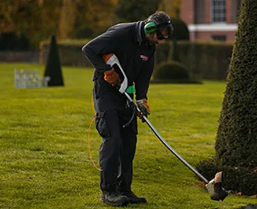 Flourish garden care team member trimming lawn edges